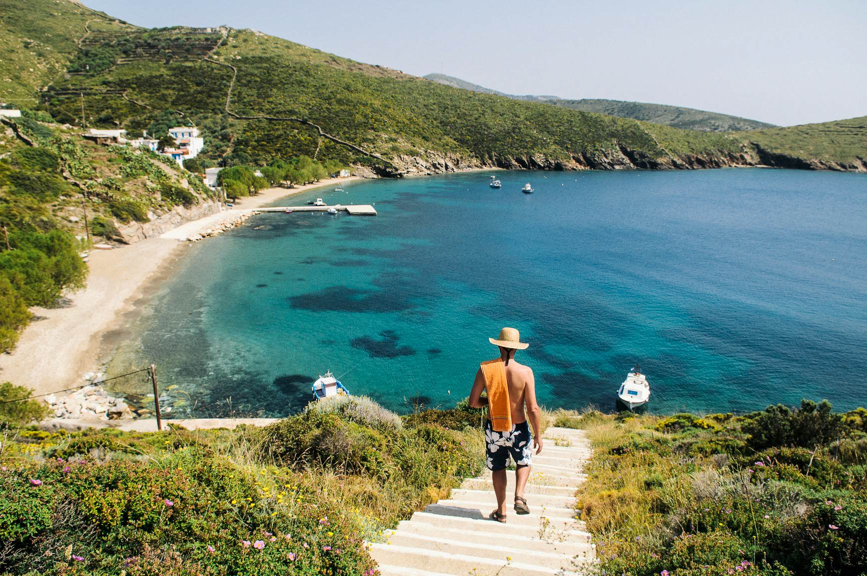 Rear view of a man walking down to a beach on Fourni Island, Greece.